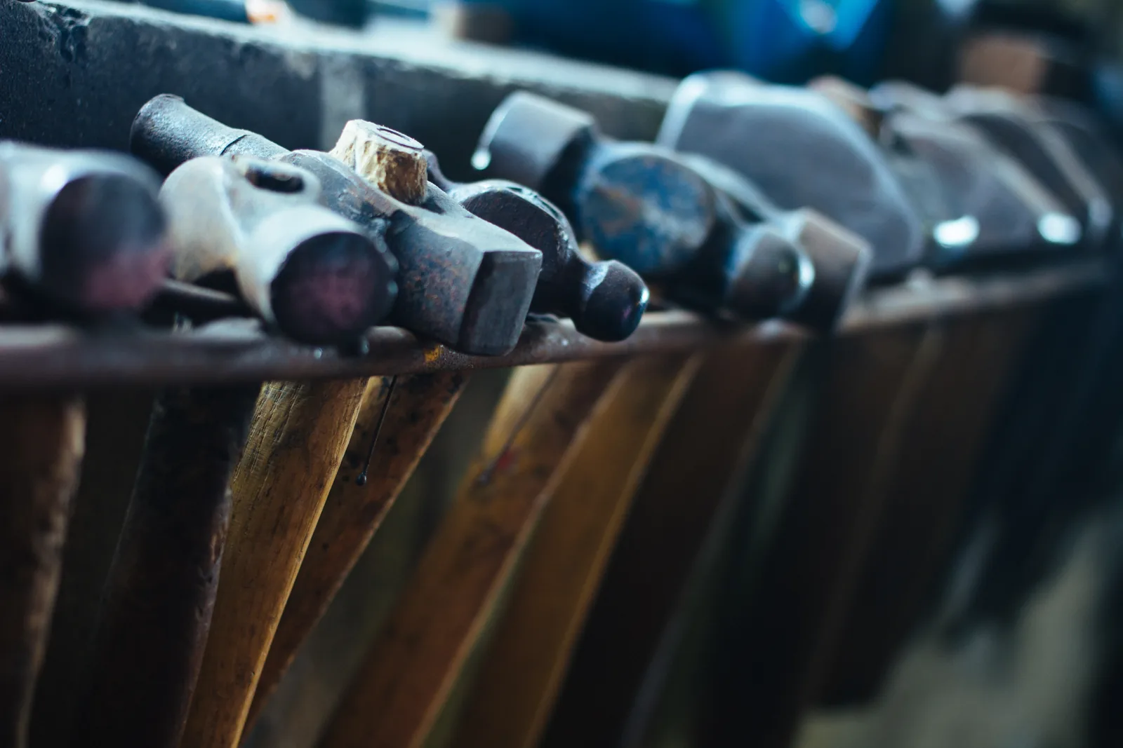 A row of hammers hanging on a rack
